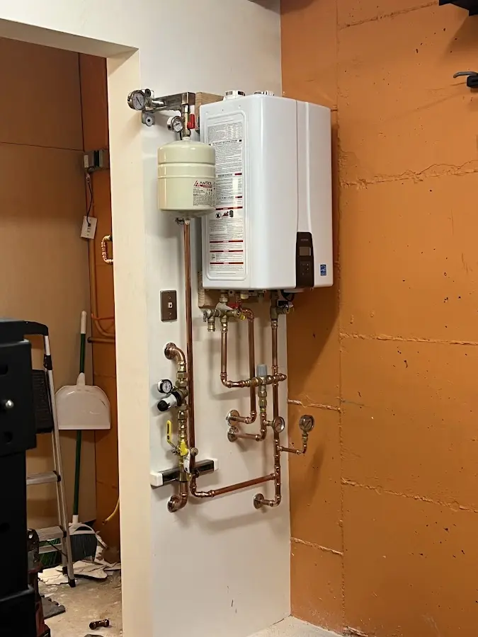 Plumbing technician inspecting water heater connections in Jamestown